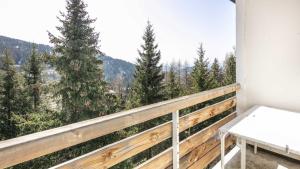 a balcony with a table and a view of trees at Hippocampe 20 - Appt cosy 4-6 pers in Chamrousse