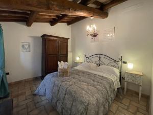 sypialnia z łóżkiem i żyrandolem w obiekcie La Casa di LucaPietro Dimora Storica w mieście Spoleto