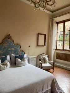 a bedroom with a large bed and a chair at 1550 Residenza d’Epoca in Siena