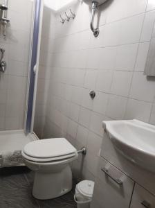 La salle de bains blanche est pourvue de toilettes et d'un lavabo. dans l'établissement La cassetta di Ninuccia, à Scafati