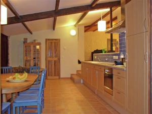 a kitchen with a wooden table and blue chairs at Tranquil holiday home in Carc s with private pool in Carcès