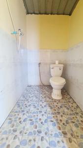a bathroom with a toilet and a tiled floor at Plankton Bungalow and Camping in Koh Rong Island