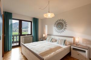 sypialnia z dużym łóżkiem i dużym oknem w obiekcie Ferienwohnung Kaiserpanorama - Alpenmagie Suites w mieście Oberaudorf