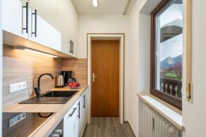 a kitchen with a sink and a window at Ferienwohnung Kaiserpanorama - Alpenmagie Suites in Oberaudorf