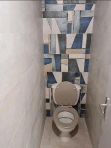a bathroom with a toilet with a tile wall at commealaferme71.vacances in Montret