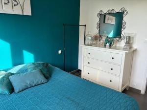 ein blaues Schlafzimmer mit einem Bett und einer Kommode in der Unterkunft Bougainvillers YourHostHelper in Saint-Cyr-sur-Mer