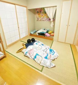 a room with two children laying on the floor at Pokémon Sleep 宝可梦的家 in Osaka