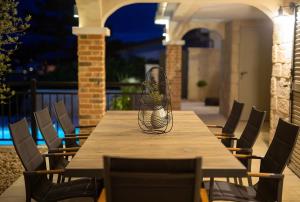a wooden table with chairs and a vase on it at Villa Sea Queen in Šilo