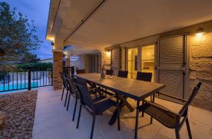 a wooden table and chairs on a patio at Villa Sea Queen in Šilo