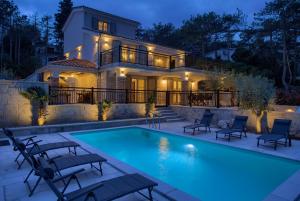 a house with a swimming pool in front of a house at Villa Sea Queen in Šilo