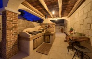 an outdoor kitchen with a stove and a stone wall at Villa Sea Queen in Šilo +45 photos