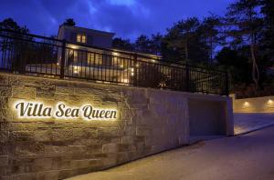 a stone wall with a sign that reads villa sea queen at Villa Sea Queen in Šilo