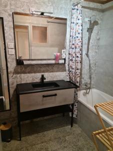 a bathroom with a sink and a mirror and a tub at commealaferme71.vacances in Montret