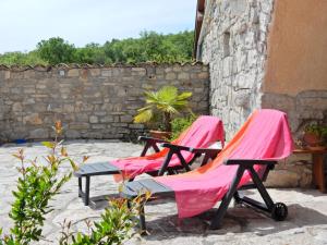 2 chaises avec des couvertures roses assises sur une terrasse dans l'établissement Amazing apartment in Lanas with large garden, à Lanas