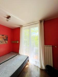 a bedroom with a bed and a large window at Cosy room Aleja Kijowska in Krakow