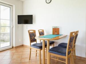 a dining room with a table and four chairs at Pretty farmhouse in the Allg u with Alps views in Bernbeuren