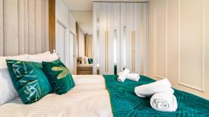 een bed met groene en witte handdoeken erop bij Plac Unii Centrum - Comfy Apartments in Gdynia
