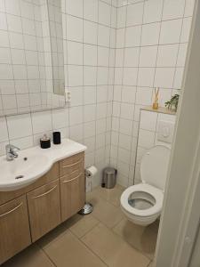 a white bathroom with a toilet and a sink at Montana Guest House. in Lillestrøm