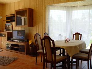 una sala da pranzo con tavolo e TV di Cottage Heringsdorf a Bansin