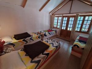 um quarto com três camas e janelas em Tides by TB em Canacona