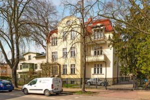 una furgoneta blanca estacionada frente a un edificio en Dom & House - Apartment Chopina 37 Supreme en Sopot