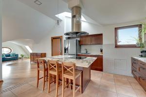 a kitchen with a large island with chairs and a counter at Dom & House - Apartment Chopina 37 Supreme in Sopot
