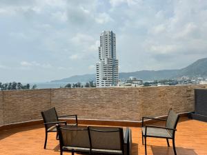 a group of chairs sitting on a balcony with a building at Condo Minium Patong Phuket in Patong Beach
