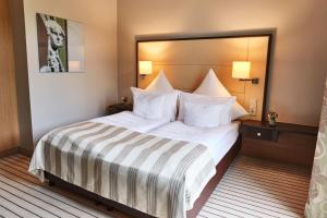 a hotel room with a large bed with white sheets at Steigenberger Hotel Bad Neuenahr in Bad Neuenahr-Ahrweiler +26 photos
