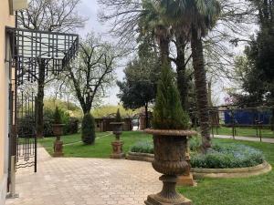 een stenen vaas met een boom in een tuin bij Locanda di Casa Spadoni in Faenza