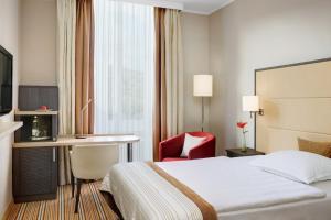 a hotel room with a bed and a desk at Steigenberger Hotel Bad Neuenahr in Bad Neuenahr-Ahrweiler