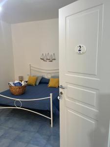 Schlafzimmer mit einem Bett mit blauer Bettwäsche und gelben Kissen in der Unterkunft Casa San Domingo in Marina di Camerota