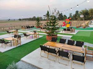 a park with tables and chairs and a playground at บ้านสวนกุหลาบแก้วรีสอร์ท in Ban Mae Lai