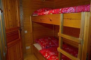 a bedroom with two bunk beds in a cabin at Cozy chalet with fireplace located in wooded area in Schönecken