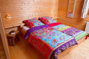 ein Schlafzimmer mit einem Bett in einem Holzzimmer in der Unterkunft Cozy chalet with fireplace located in wooded area in Schönecken