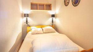 a small bedroom with a bed with two pillows at Les Marmottes -311- appt lumineux 4-6 pers in Chamrousse
