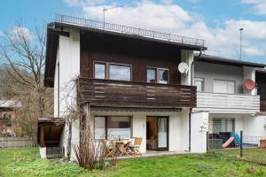 une maison avec une façade en bois et une terrasse dans l'établissement Ferienhaus Wildbarren - Alpenmagie Suites, à Oberaudorf