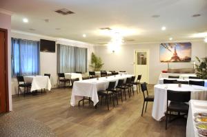 une salle à manger avec des tables et des chaises blanches dans l'établissement Pinjarra Resort, à Pinjarra