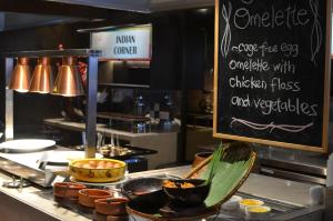 a kitchen with a counter with bowls of food at Le Meridien Kota Kinabalu in Kota Kinabalu