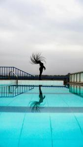 een vrouw dansend in een zwembad met haar haar in de lucht bij Hassan Furnished Superior Studio, Nairobi in Nairobi
