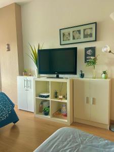 una sala de estar con TV en un armario blanco en Vamos a PERTE DE VUE Linge de maison fournie en Ampuriabrava
