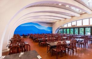 a banquet hall with tables and chairs in a room withwindows at Uvala Scott in Kraljevica