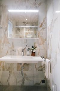 a bathroom with a sink and a marble wall at AMANTE in Belp