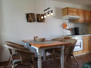 a kitchen with a table and chairs in a kitchen at Comfortable apartment in quaint holiday village in Barlin