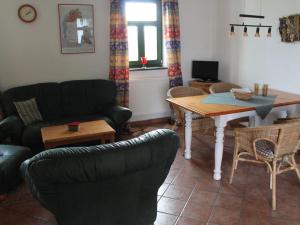 a living room with a couch and a table at Comfortable apartment in quaint holiday village in Barlin