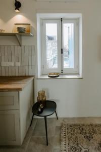eine Küche mit einem Tisch und einem Fenster in der Unterkunft Smaragda's Guest Rooms in Limassol
