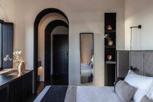 a bedroom with a bed and a large mirror at Nimbus Santorini in Oia
