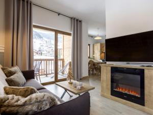 - un salon avec un canapé et une cheminée dans l'établissement Apartment near ski lift in mountain Village, à Beaufort