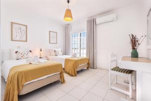 a white room with two beds and a window at Quinta Terruta by Ocvillas in Albufeira +146 photos