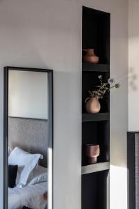 a mirror in front of a bedroom with a bed at Nimbus Santorini in Oia