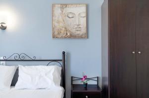 1 dormitorio con 1 cama con una pintura en la pared en Iguana studio 2, en Preveza